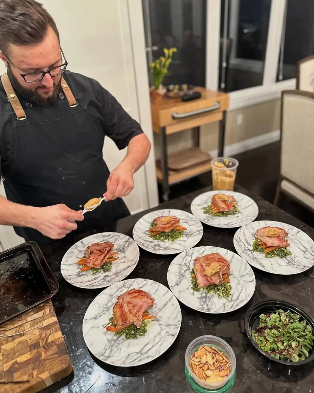 Chef Josh plating a course on the counter of a client's home