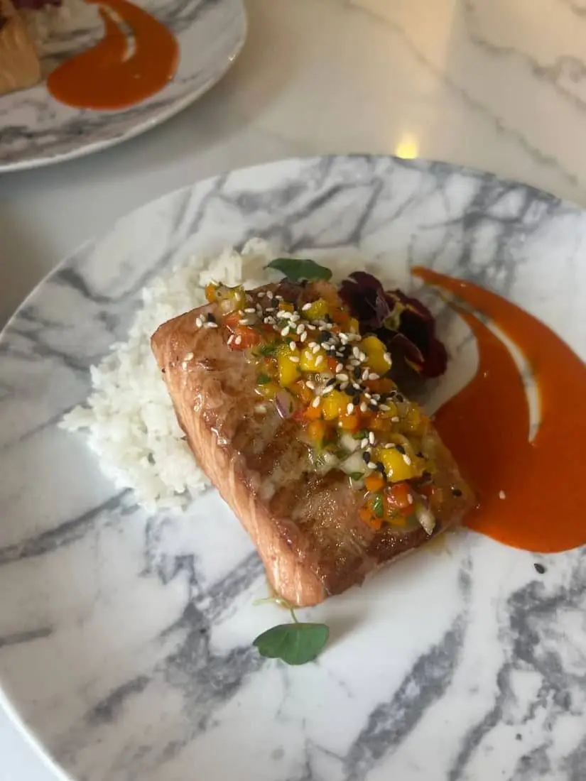 Seared salmon with mango salsa and romesco, plated by Chef Josh